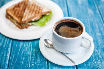 Breakfast with a cup of coffee and two toasted sandwiches