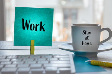 Work at home during the Coronavirus epidemic.  A card with the words Work and a cup of coffee with...