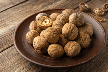 Nuts. Walnut kernels and whole walnuts on wooden table.