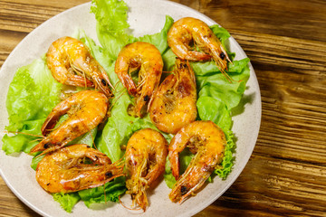 Tasty baked shrimps on a wooden table. Top view