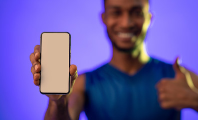 Man Showing Empty Smartphone Screen Gesturing Thumbs-Up, Blue Background