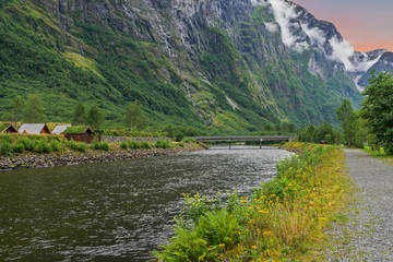Mountain landscape with rural houses and river bridge, Norway