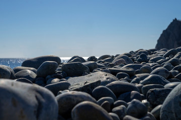 Pebble beach, large stones, sea and sky in the distance