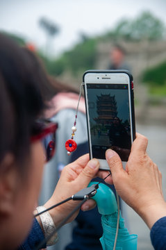 Wuhan, China - Apr 22, 2019 : Tourist taking photo with mobile of the Yellow Crane Tower, the traditional Chinese multi-storey tower located on Sheshan (Snake Hill).