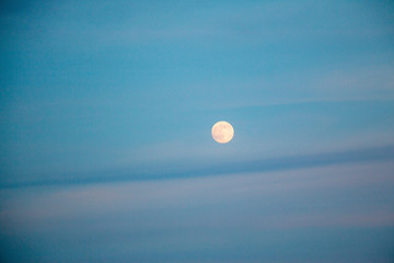 full moon in evening sky with clouds