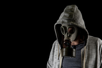 Portrait of a man in an old gas military mask on a black background. Copy space