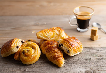 Breakfast table with croissants and cinnamon buns with fresh orange juice.