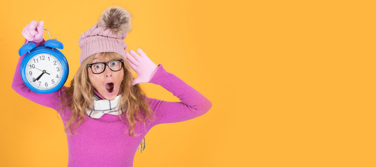isolated adult woman with warm clothes and clock on color background