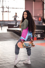 Fototapeta na wymiar beautiful curly black girl with a skateboard