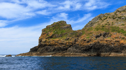 Fototapeta na wymiar Cape Brett in the Bay of Islands, New Zealand. The tip of the cape jutting out into the sea 