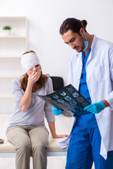 Young head injured woman visiting young male doctor