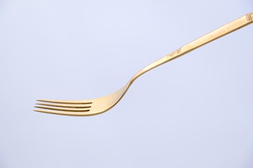 Golden fork isolated on white background