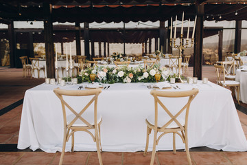 banquet table decorated with compositions of flowers and greenery