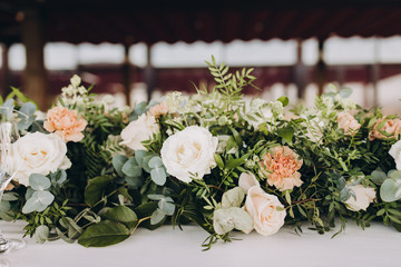banquet table decorated with compositions of flowers and greenery