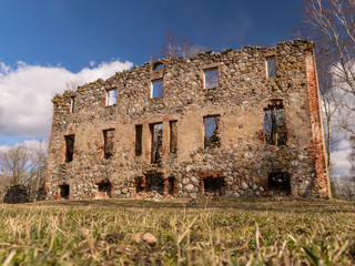 wonderful landscape with ruins of an old manor house, trees in the old building, early spring