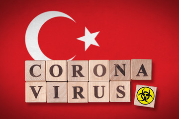 Turkey flag background and wooden blocks with letters spelling CORONAVIRUS and quarantine symbol on it. Novel Coronavirus (2019-nCoV) concept for an outbreak occurs in Turkey.