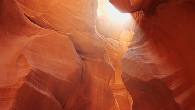 Dust flies in the sun in antelope canyon. Zoom out shot of red walls of Antelope Canyon in Arizona, USA