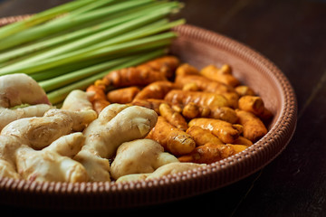 Natural Herbal ingredients with ginger, turmeric and lemongrass on wood background