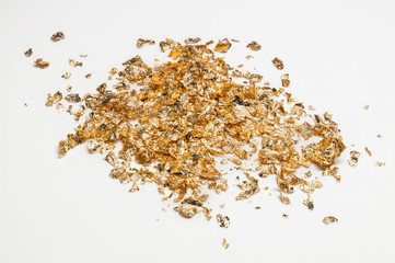 Shiny pieces of gold leaf on a white background 