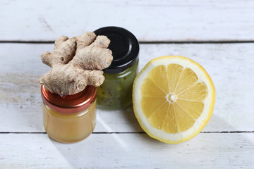 glass jar of homemade jam and honey with ginger and lemon on wooden table