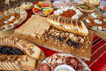 Fresh baked sweet bread and autumn nuts and apples surrounded by traditional food on a table at a...