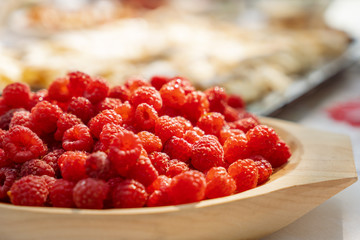 Fresh raspberries on a wooden plate detail macro photography