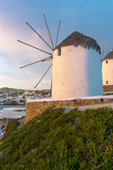 The ancient windmills of the island of Mykonos with a cloudy sky in the background