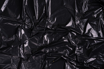 Creative backdrop from crumpled black plastic polyethylene package