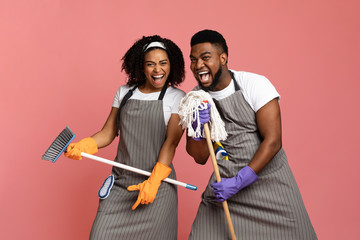 Playful Black Couple Using Mop As Microphones, Having Fun During Spring-Cleaning