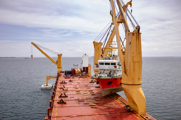 a scientific ship is loaded onto a deck of a heavy lift vessel  by tandem of two cranes with a pontoon installed © Kirk