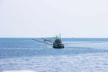 Traditional green thai fishing boat floating in the bay of thailand near koh chang on day the bright sky.