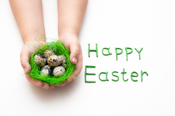 hands of a child holding a nest with quail eggs on a white background, Easter holiday