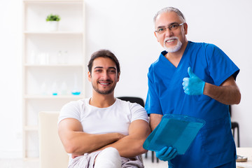 Obraz premium Leg injured man visiting old doctor in first aid concept