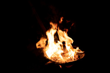 Red orange flame from the fire on the pan roasting cashews..fire,heat energy that ignites fuel at...