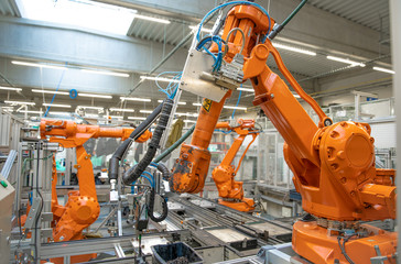 orange robot arms on the production line. controlled by a computer with artificial intelligence