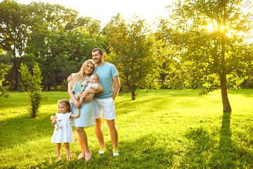 Fototapeta premium Parents with baby stands on grass in the park