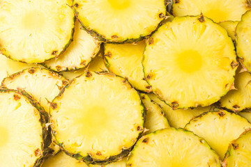 Pineapple juicy yellow slices background. Top view.
