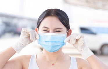 Closeup woman wearing face mask for protect air polution or virus covid 19 with white glove in car park of supper market  background, health care and medical concept