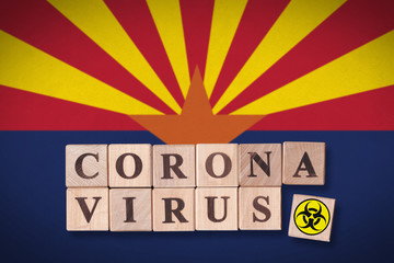 The state of Arizona flag and wooden blocks with letters spelling CORONAVIRUS and quarantine symbol on it. Novel Coronavirus (2019-nCoV) concept for an outbreak occurs in Arizona, US.