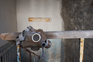 Gasmask hanging on staircase  of abandoned school in Pripyat near Chernobyl in Ukraine