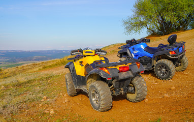 Two   atv quad motorbikes standing on the top of mountain. sunny weather. leisure tourism hobby concept. outdoor adventures