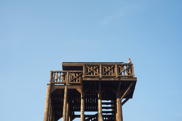 Caucasian man or girl observes sky from observation tower