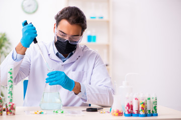 Young male chemist in drug synthesis concept - obrazy, fototapety, plakaty