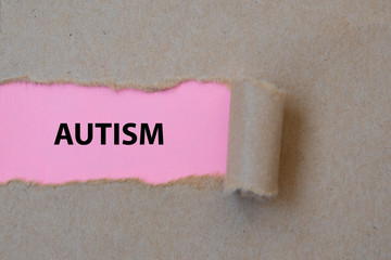 AUTISM, word written under torn paper. Image.