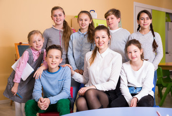 Friendly group of pupils with teacher in schoolroom