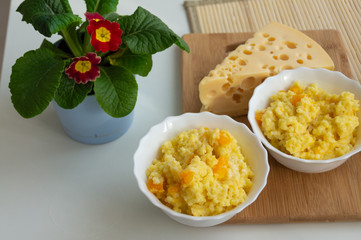 millet porridge with pumpkin and cheese on the table