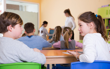 Fototapeta na wymiar Schoolchildren chatting during lesson