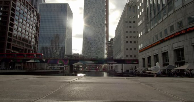 DLR train passes trough Canary Wharf in London bird in front