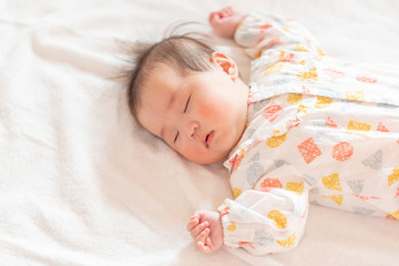 明るい部屋の中でぐっすりと眠るかわいい赤ちゃん