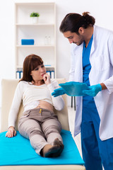 Injured young woman visiting young male doctor